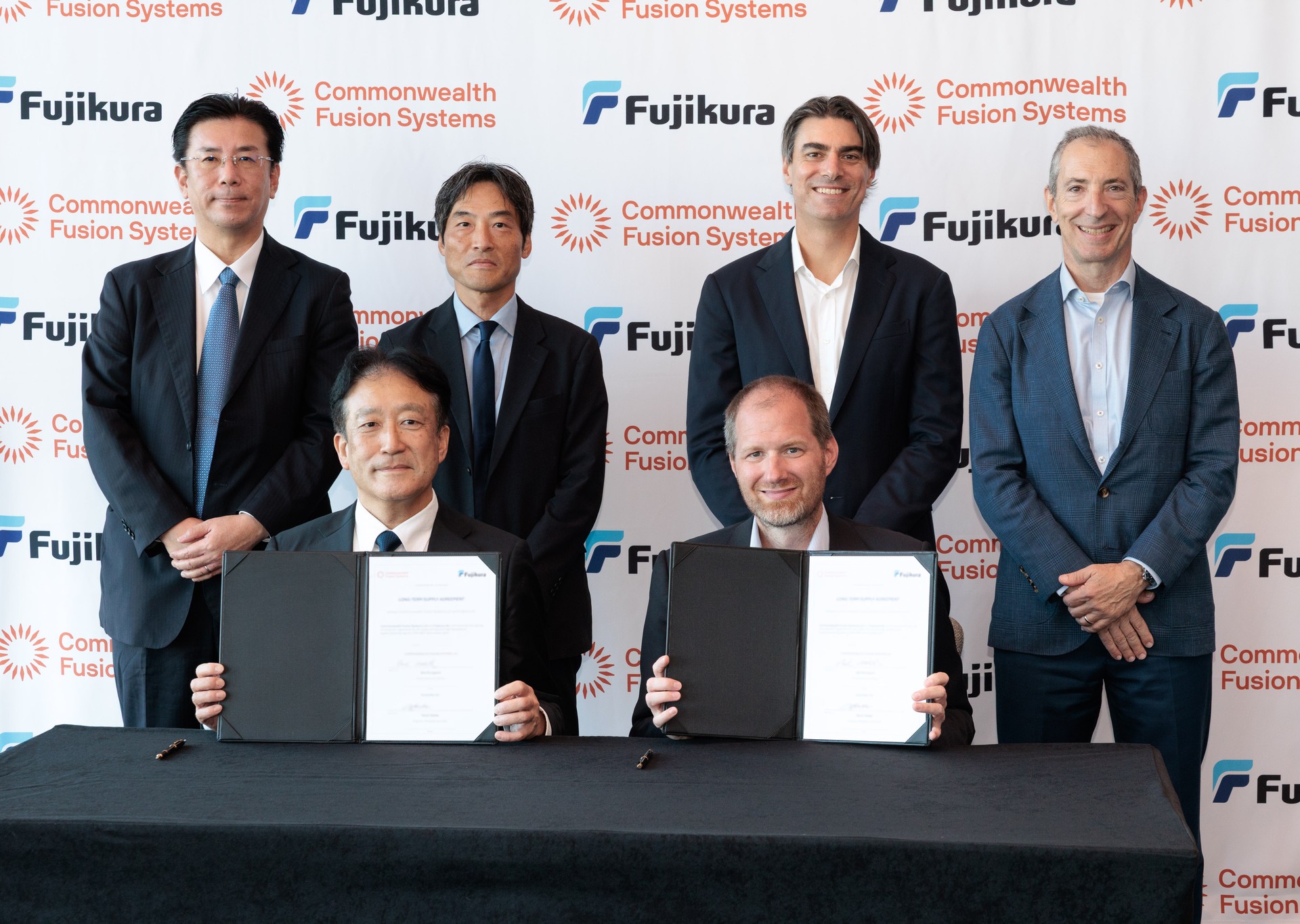 CFS and Fujikura executives holding the signed agreement.